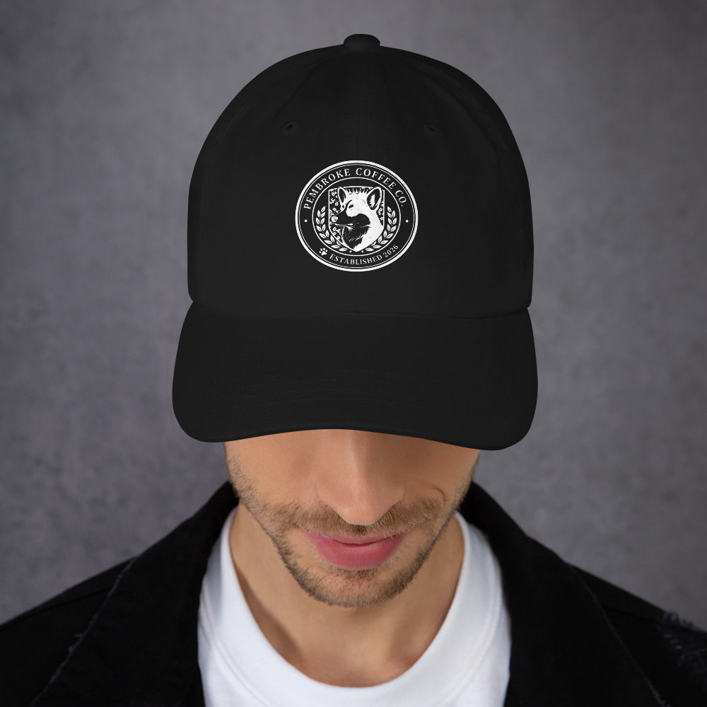 Black dad hat with embroidered logo of a coffee brand, featuring a low profile and adjustable strap.