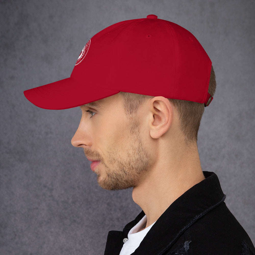 Profile view of a man wearing a red dad hat with a curved visor and adjustable strap.