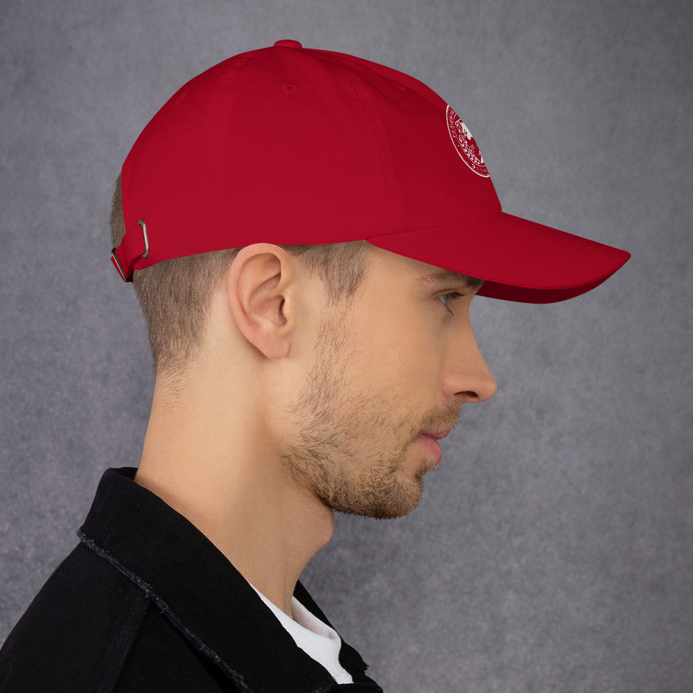 Profile view of a man wearing a red Dad hat with a curved visor and adjustable strap.