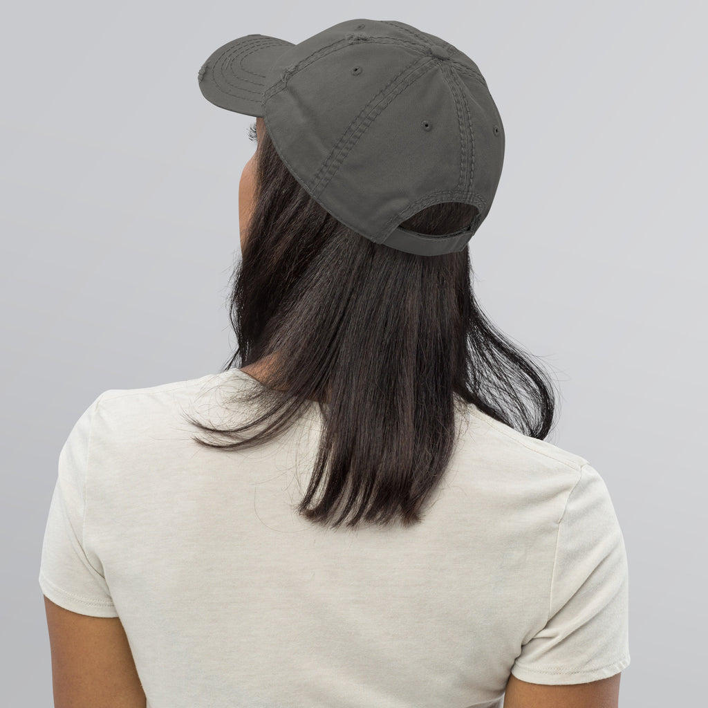 Back view of a woman wearing a Distressed Dad Hat in gray, showcasing the soft crown and distressed design.