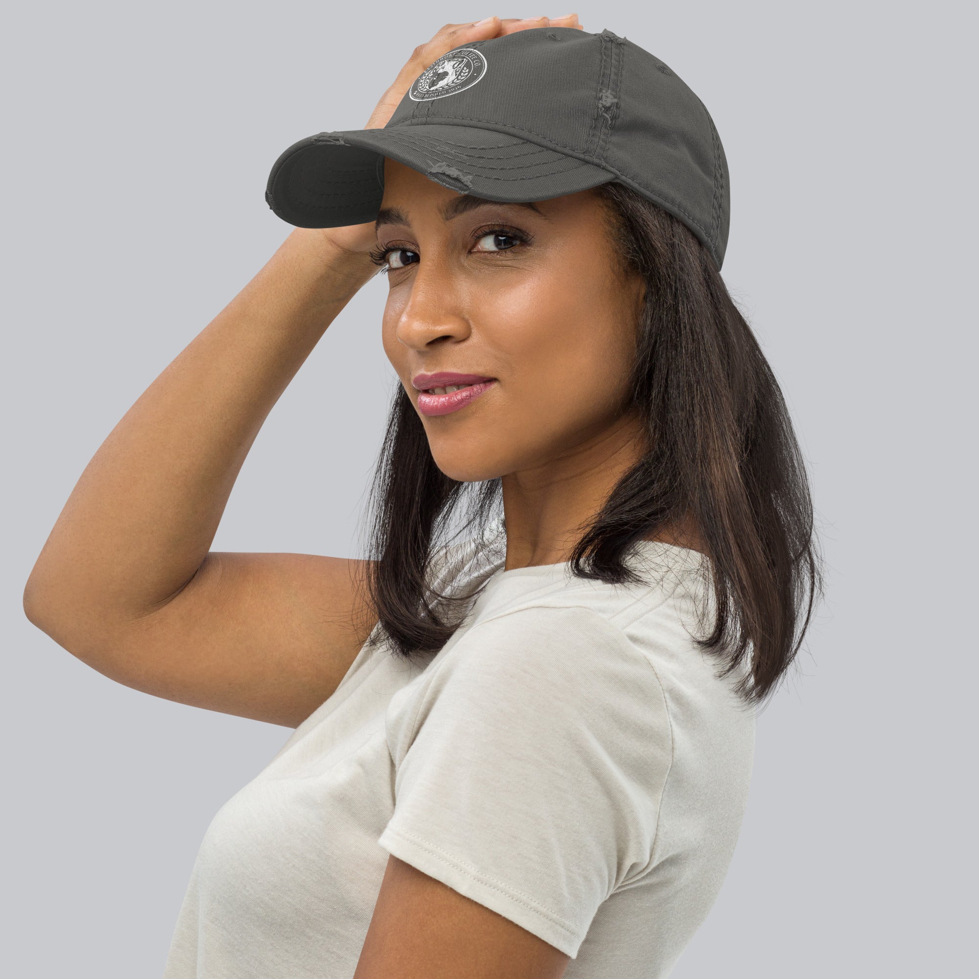 Woman wearing a Distressed Dad Hat, showcasing its stylish design and soft crown fabric.