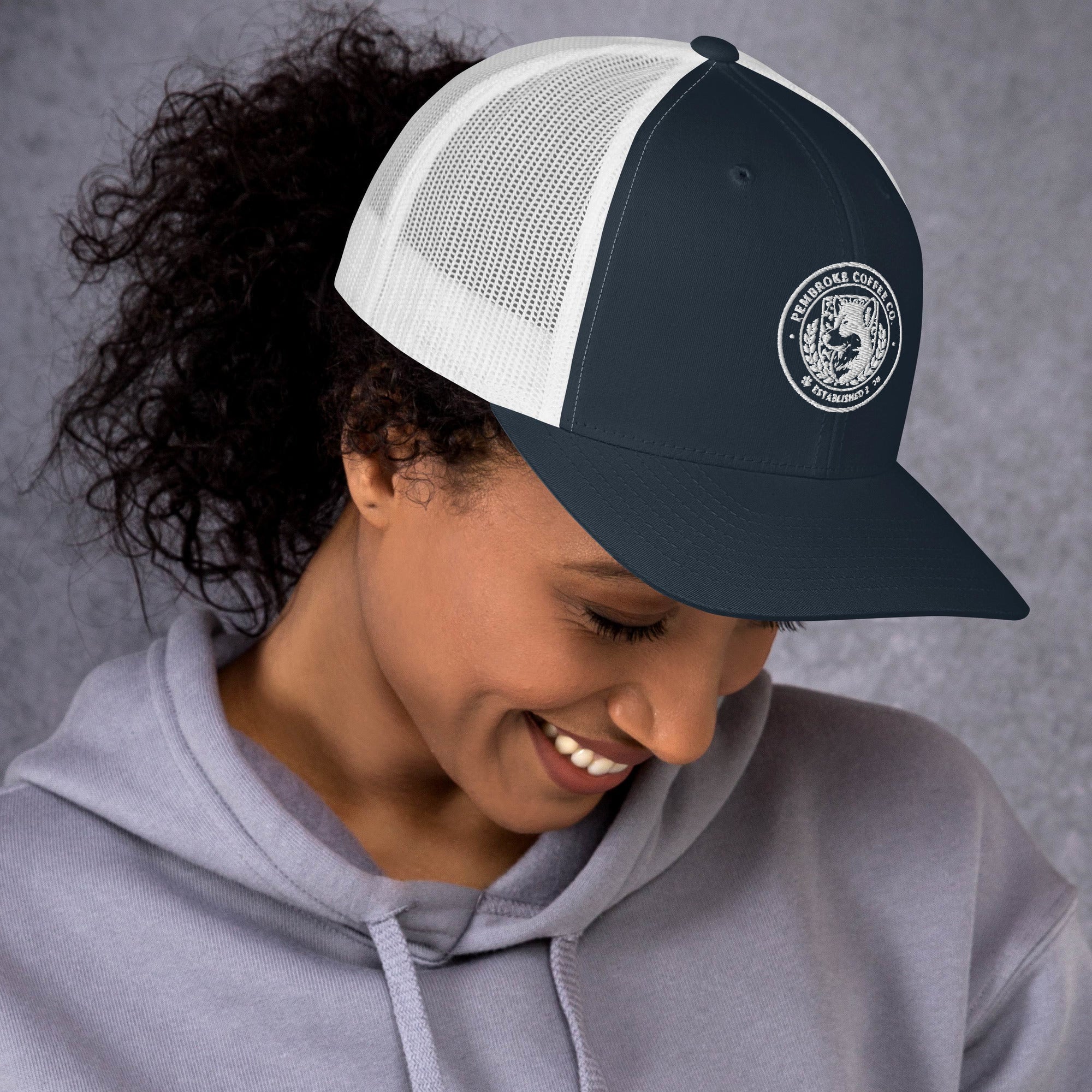Person wearing a stylish Trucker Cap with mesh back, perfect for sunny outdoor days.