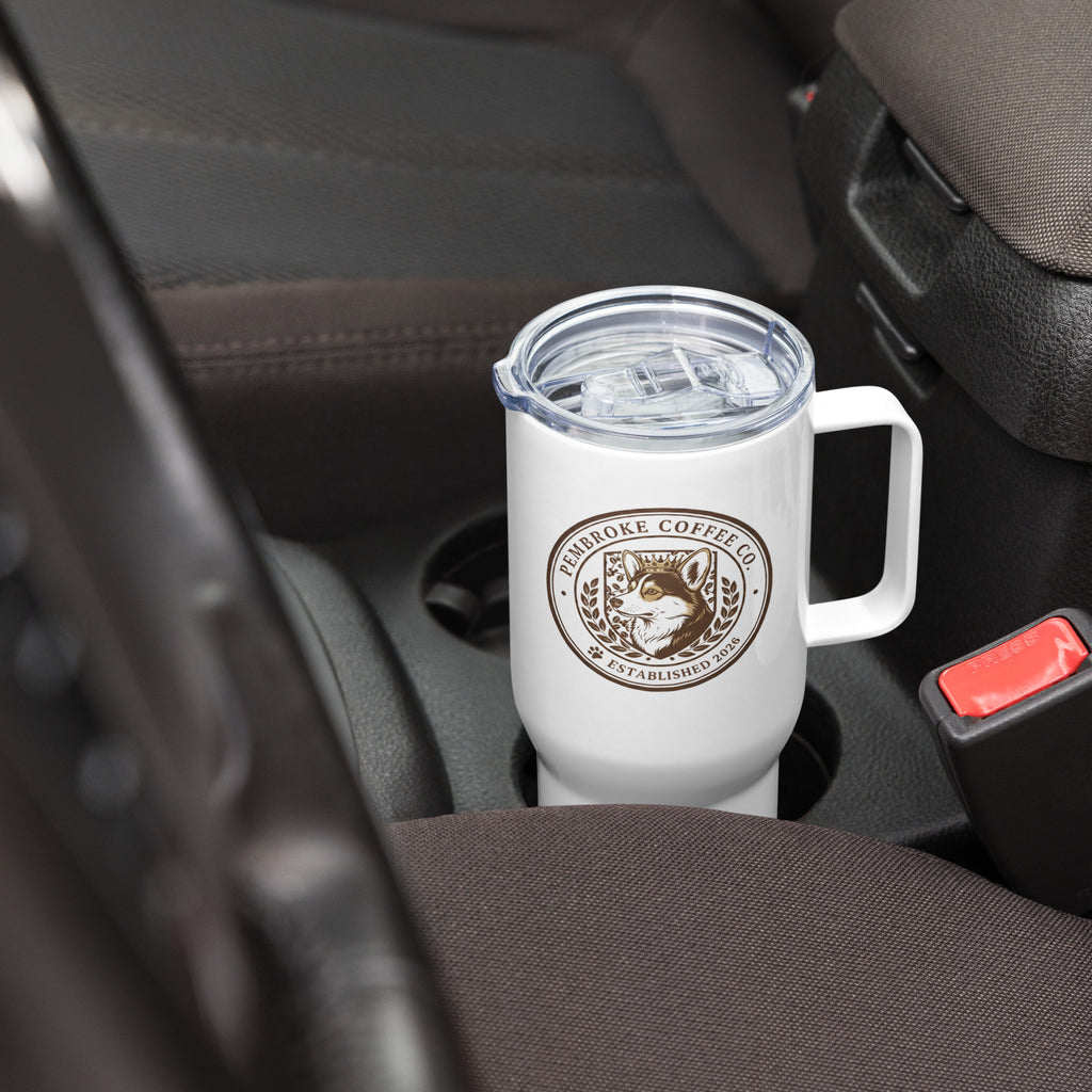 Travel mug with a handle placed in a car cup holder, showcasing its sleek design and comfortable handle.