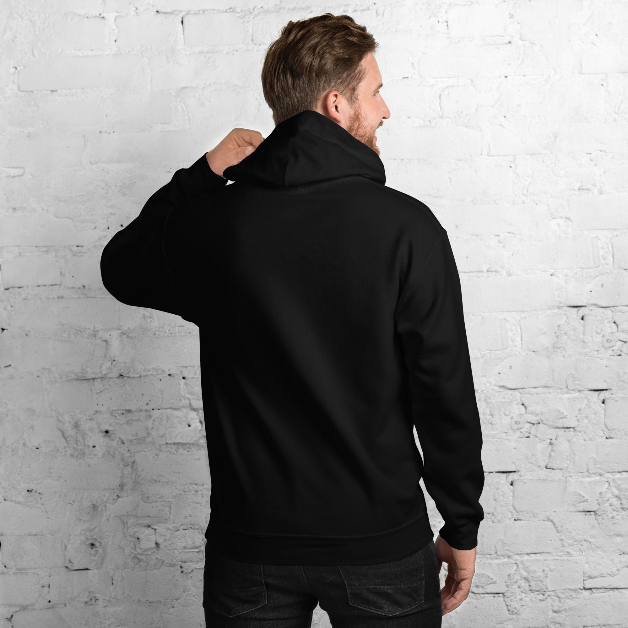 Man wearing a black unisex hoodie with a double-lined hood, shown from the back.