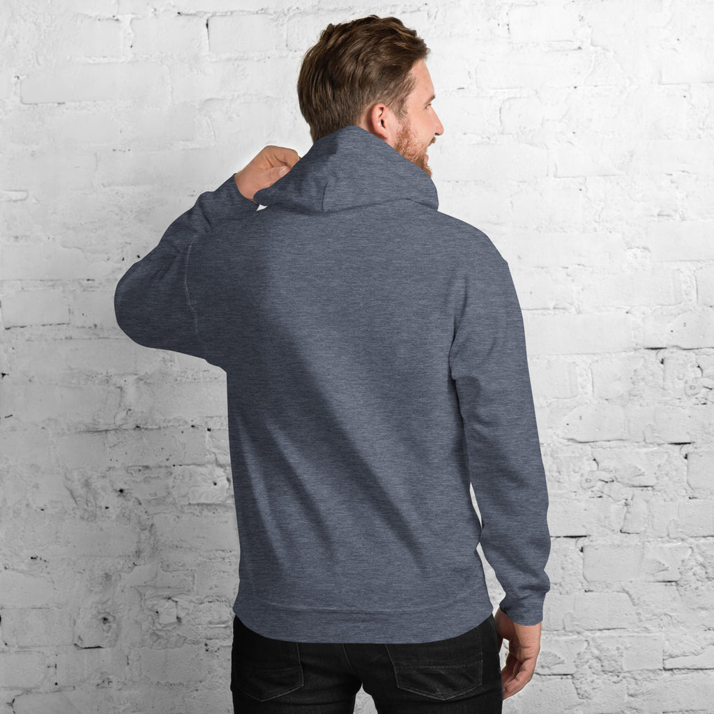 Back view of a man wearing a cozy Unisex Hoodie against a brick wall.