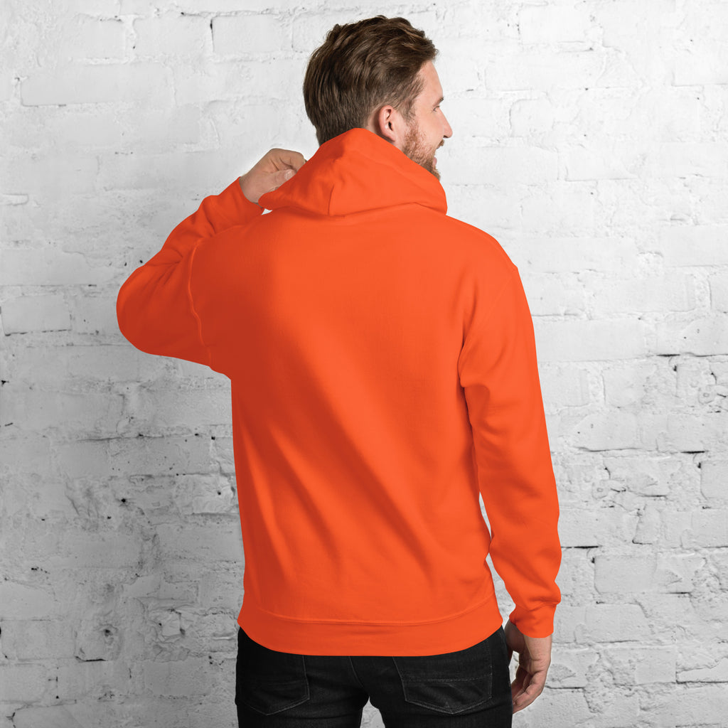 Man wearing a bright orange Unisex Hoodie, showing the back, against a white brick wall.