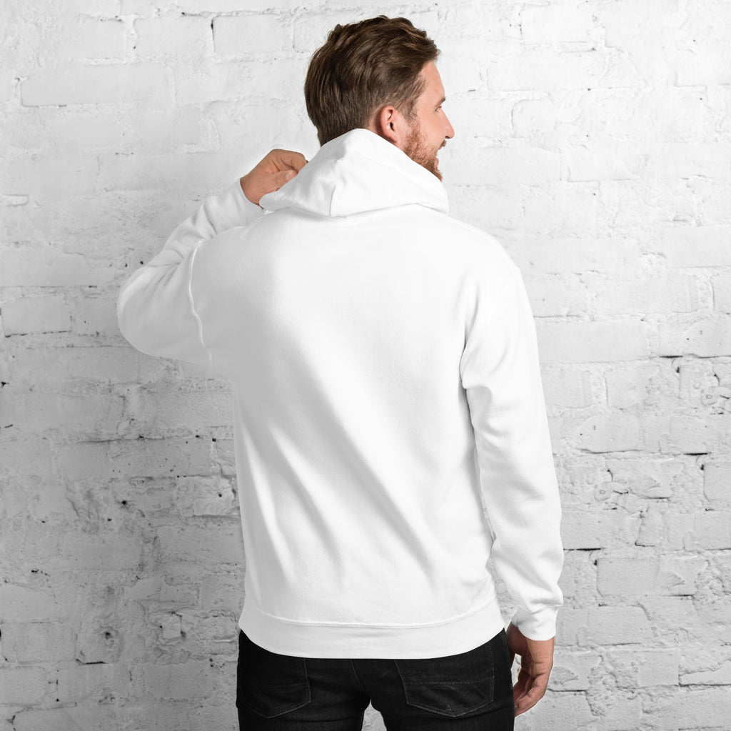 Back view of a man wearing a Unisex Hoodie against a white brick wall.