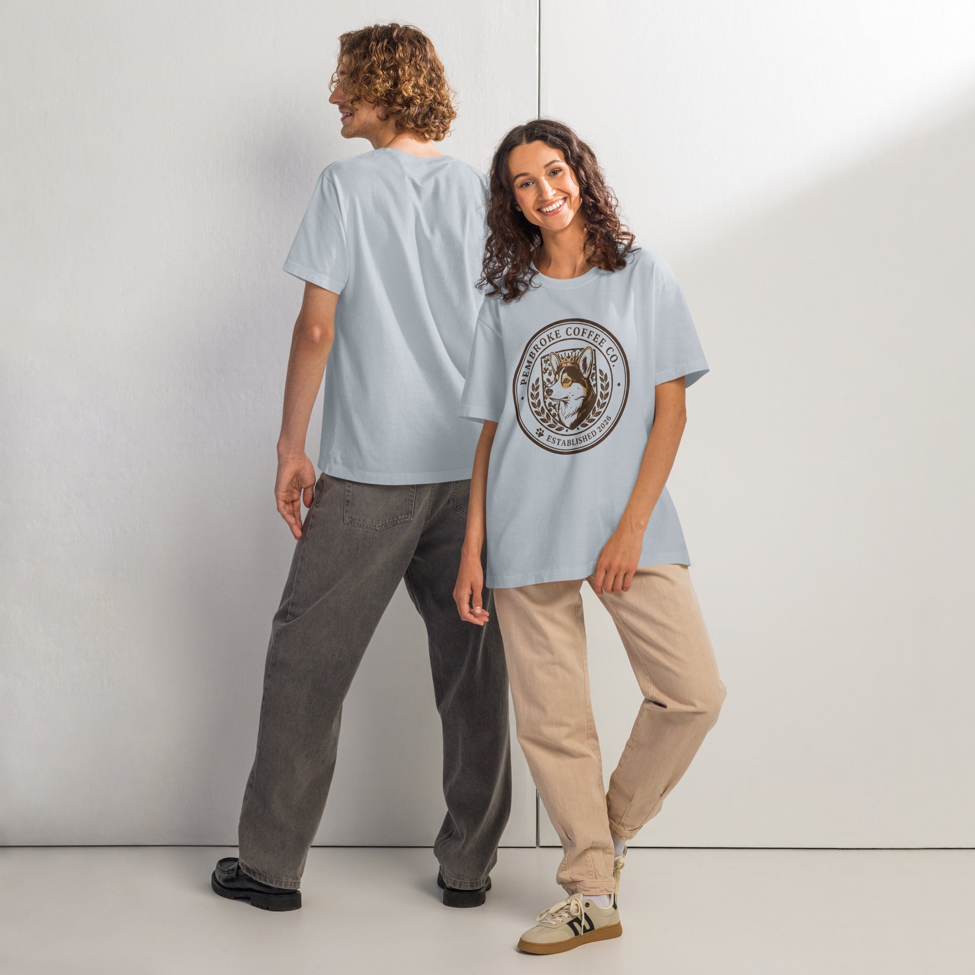 Two models wearing a unisex oversized t-shirt in light blue, showcasing laid-back streetwear style.