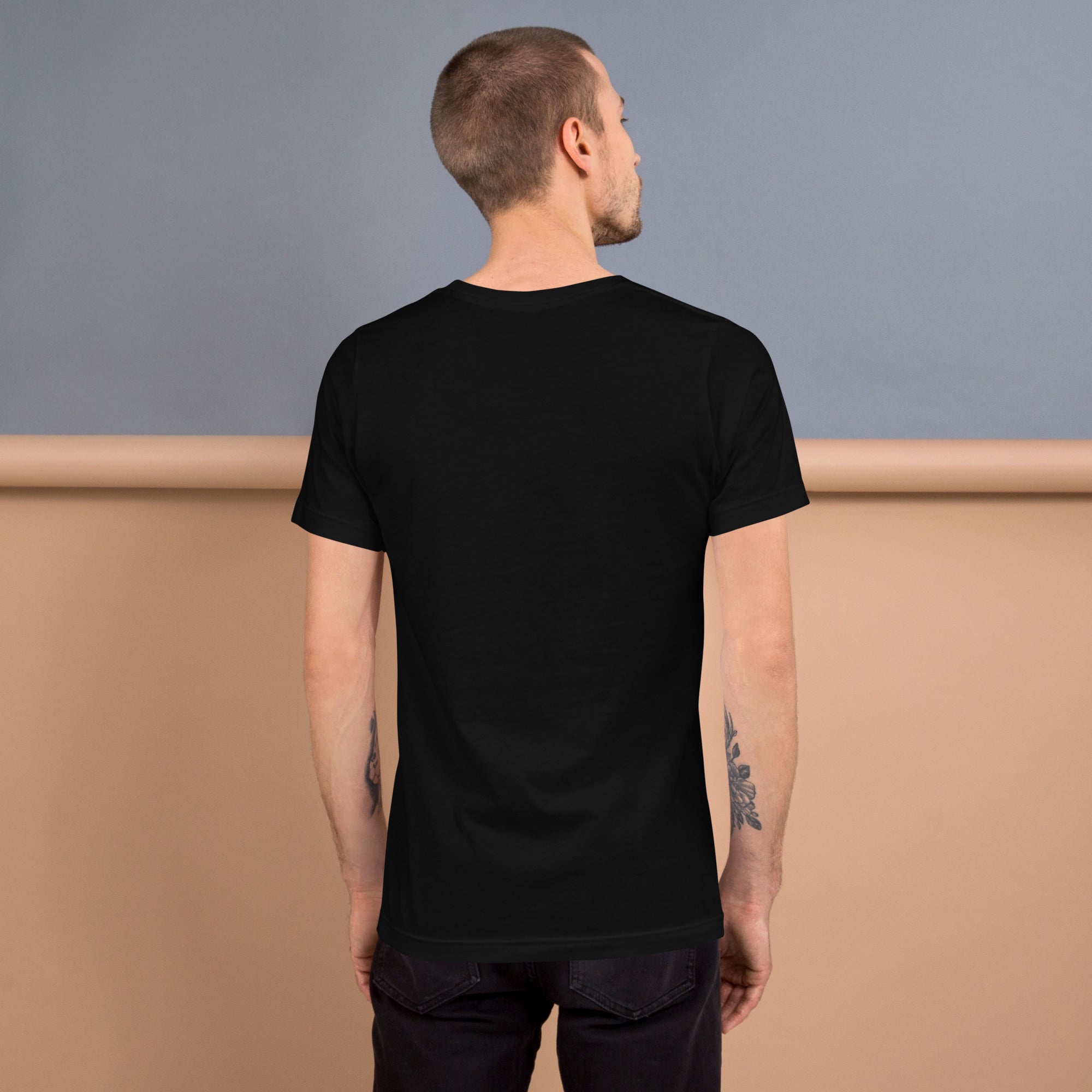 Back view of a man wearing a black Unisex t-shirt, showcasing its stylish design and comfortable fit.