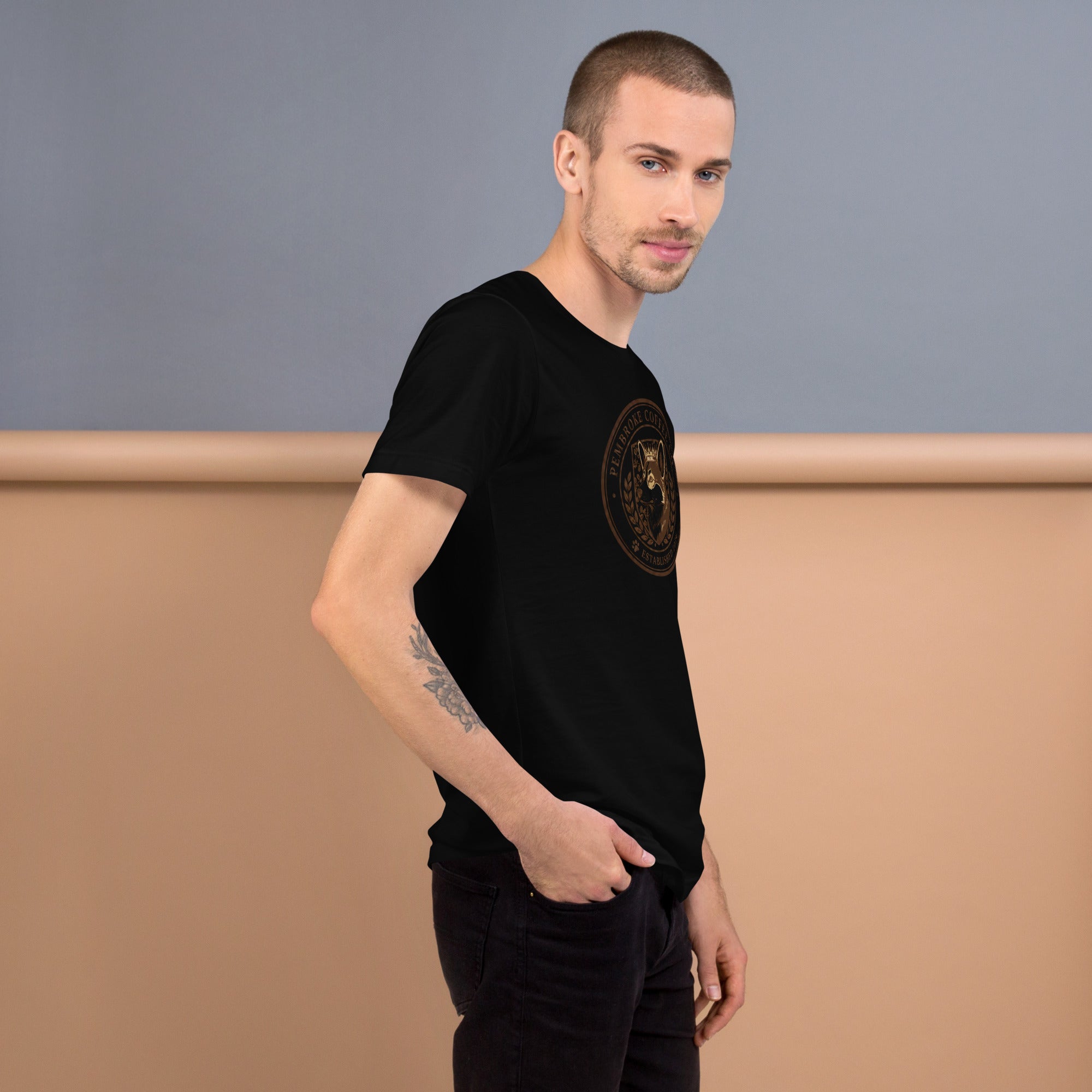 Man wearing a black unisex t-shirt with a logo, showcasing its soft and comfortable fabric.